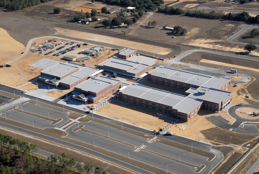 Aerial view of a school building under construction, showcasing past projects.
